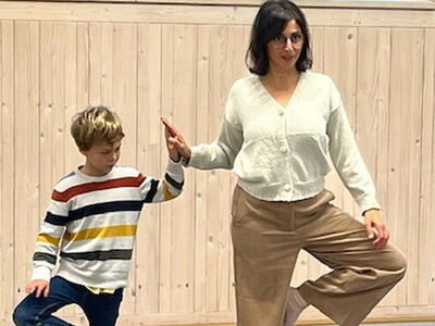 Ein Schüler mit Frau Turhan bei einer Yogaübung