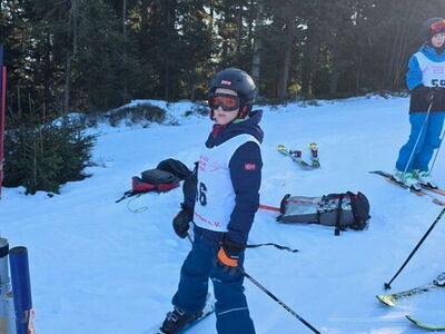 Ein Schüler steht auf Skiern im Schnee