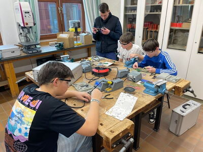 Schüler tüfteln gemeinsam auf einer Werkbank