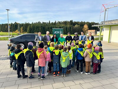 Schüler tragen alle die von den Ehrengästen überreichten Leuchtwesten